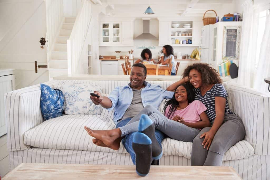 Family sitting on couch watching television