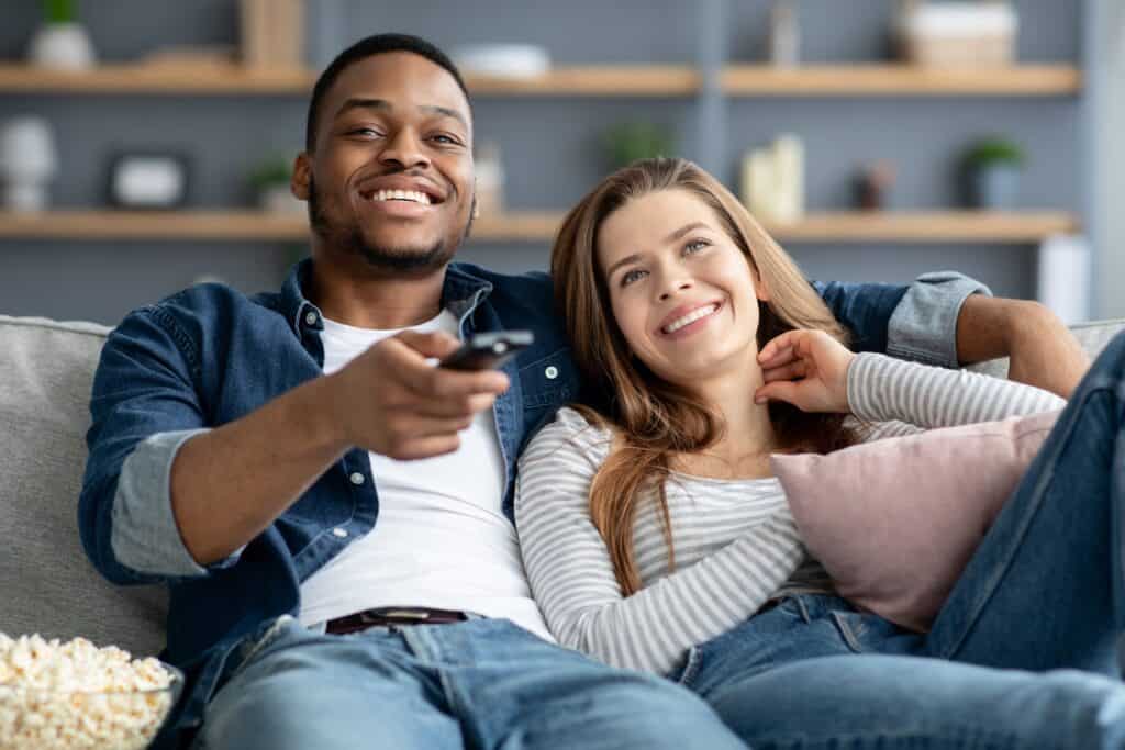 couple watching tv, holding remote