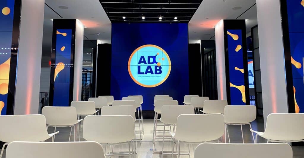 Chairs in front of a screen with the AdLab logo